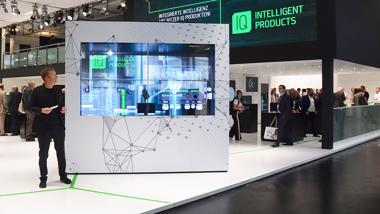 Großer Messestand von Bitzer, Ansicht auf transparenten OLED-Monitor Eyecatcher mit Moderator und live Produkt-Präsentation in Nürnberg auf der Chillventa 2018