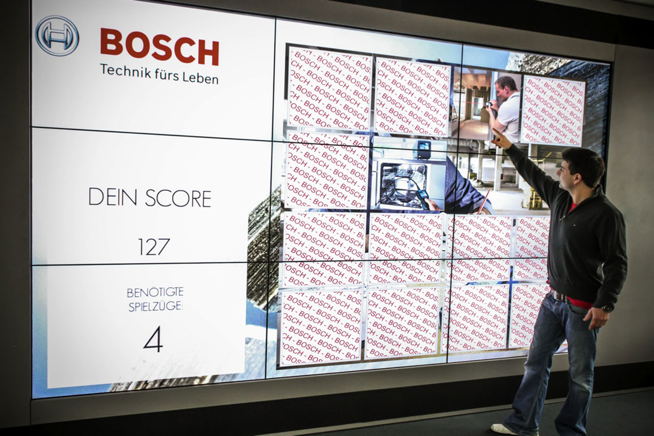 Touch Memory1 s 1 Mann spielt Memory Touch Game von Bosch auf einem großen Bildschirm