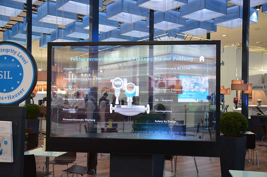 Transparenter OLED-Monitor mit digitaler Produktpräsentation auf dem Messestand von Endress+Hauser, 2018