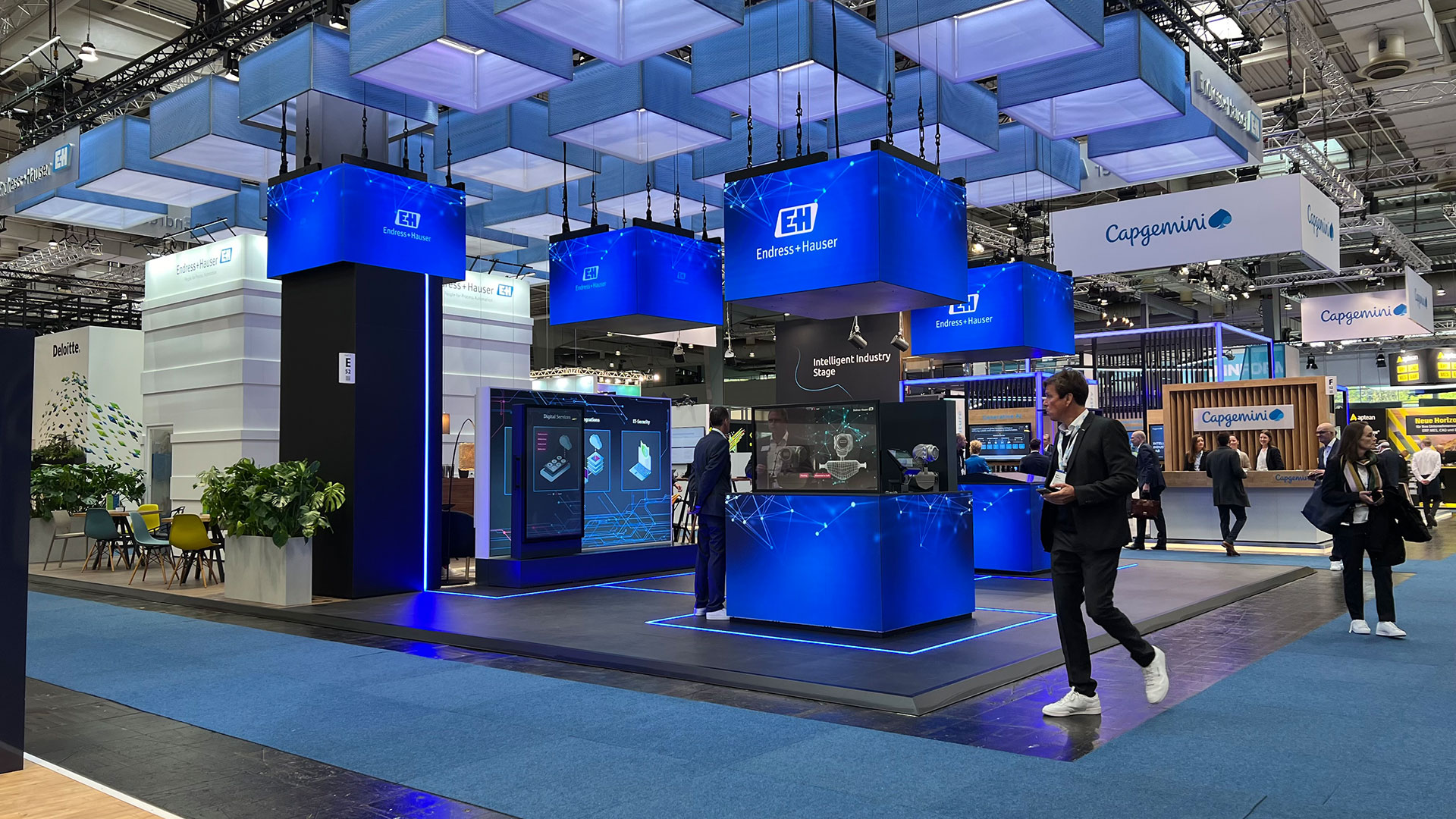 Messestand von Endress+Hauser für die Hannover Messe 2024 mit mehreren Led-Cubes und modernen Messe-Medien