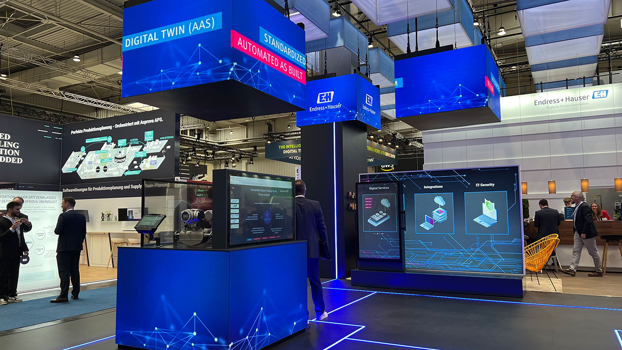 Messestand von Endress+Hauser für die Hannover Messe 2024 mit mehreren Led-Cubes und transparentem Oled-Monitor