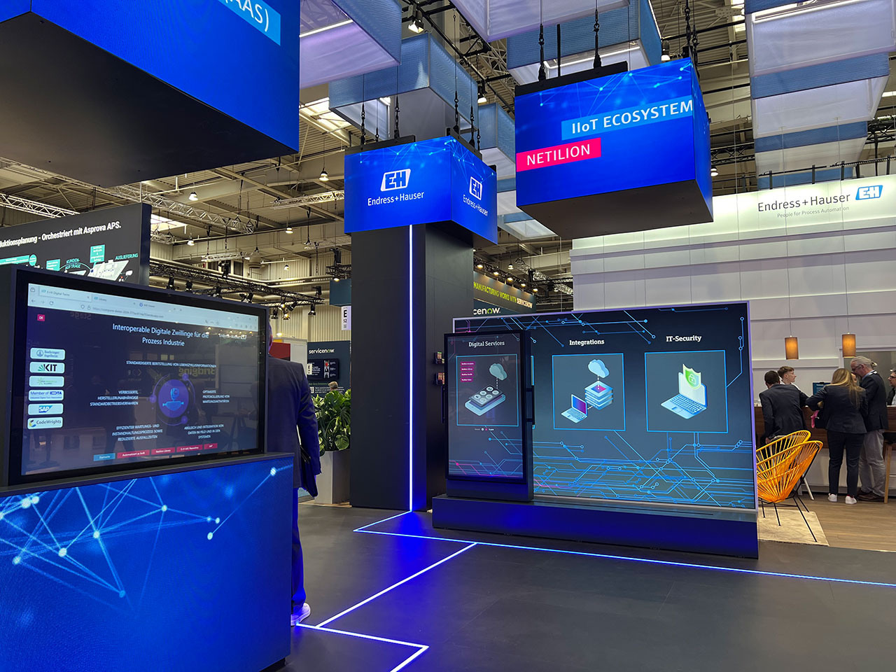 Messestand von Endress+Hauser für die Hannover Messe 2024 mit mehreren Led-Cubes und transparentem Oled-Monitor